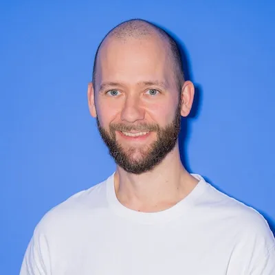 A bald man with a beard on blue background