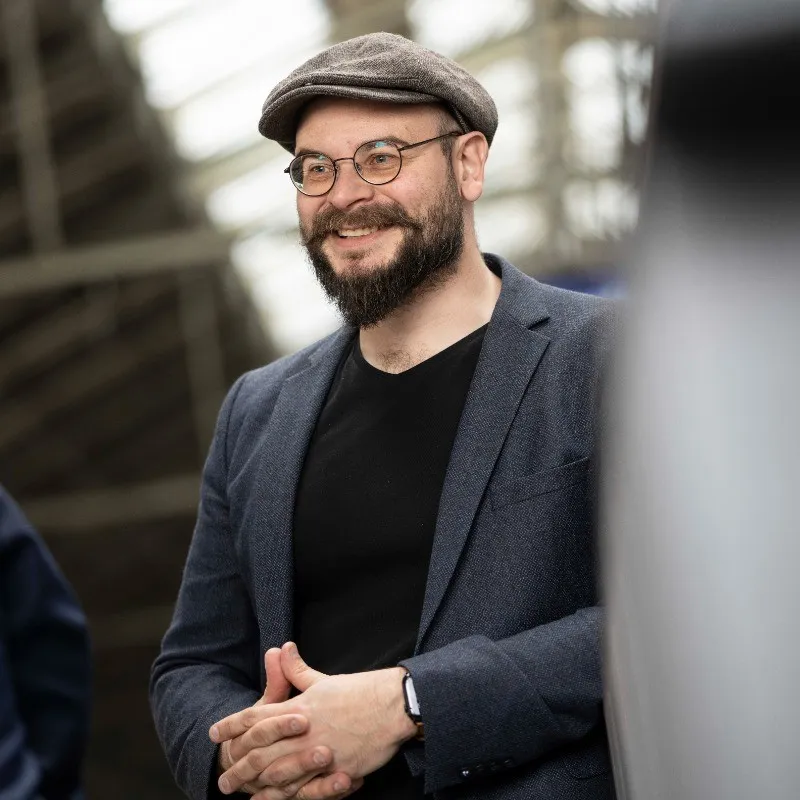 A bald man with a beard on blue background